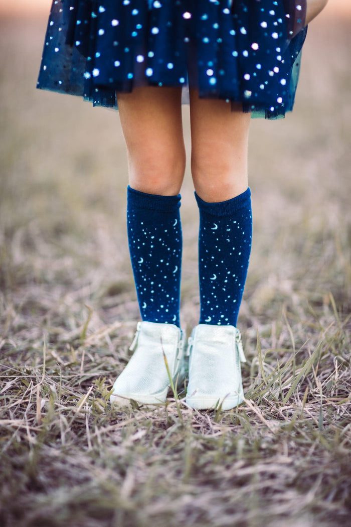 Space Kid Costume Knee High Socks - Default Title - Navy knee-high socks with white star patterns worn with white shoes and a dark blue dress with scattered stars.