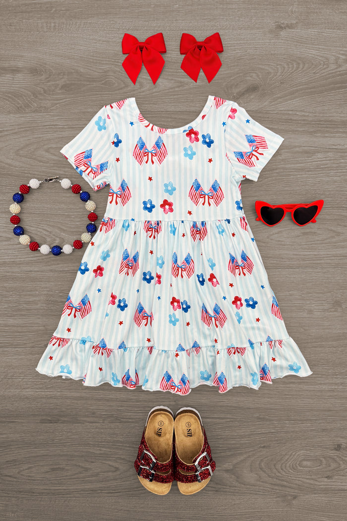 American Flag & Flowers Stripe Dress - 6-12 Months - White dress with red and blue floral and stripe pattern, with short sleeves and ruffled hem, styled with red bows, red heart .