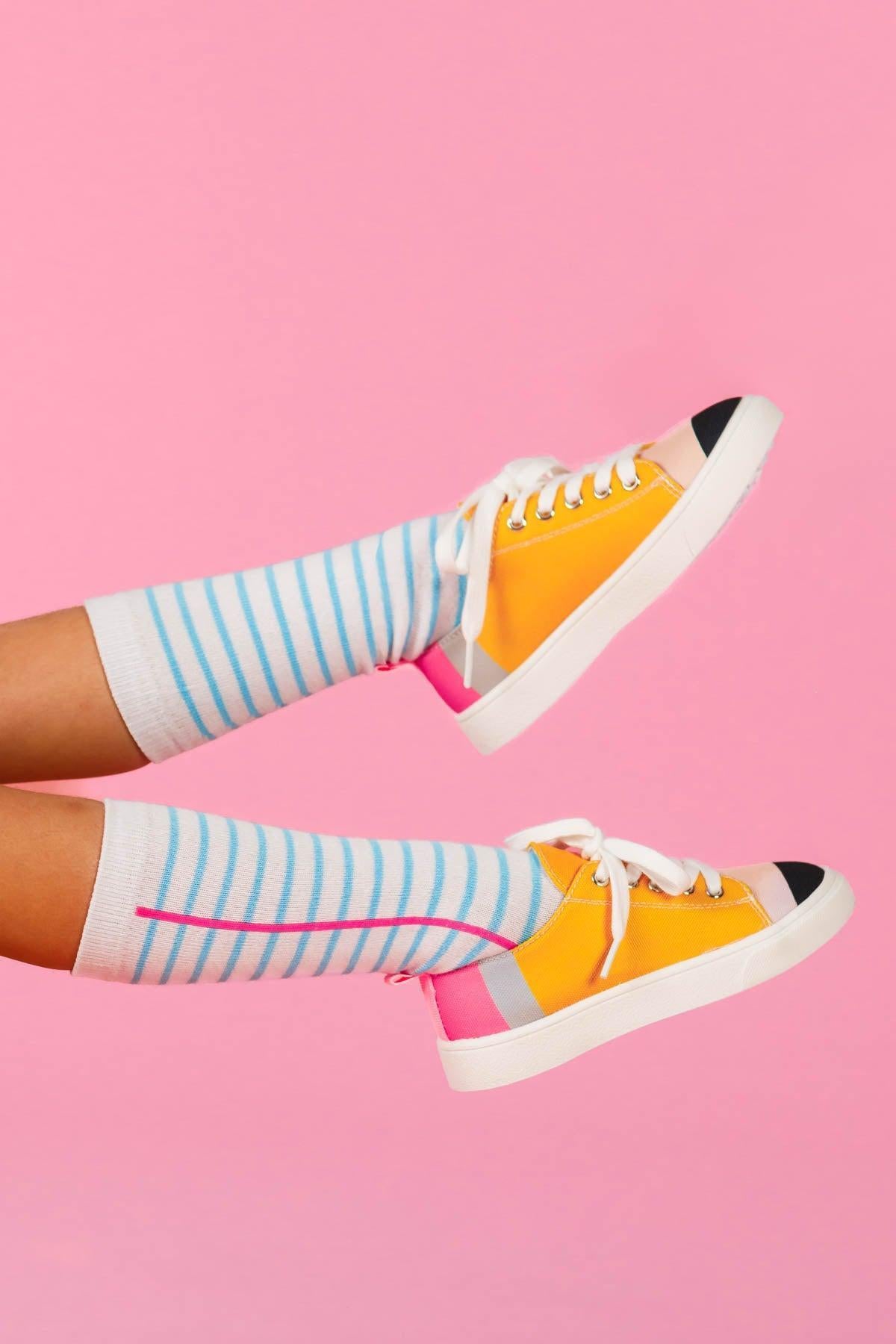 Pencil Sneakers - KIDS-8T - Yellow canvas sneakers with white soles and black toe caps worn with striped blue and white knee-high socks.