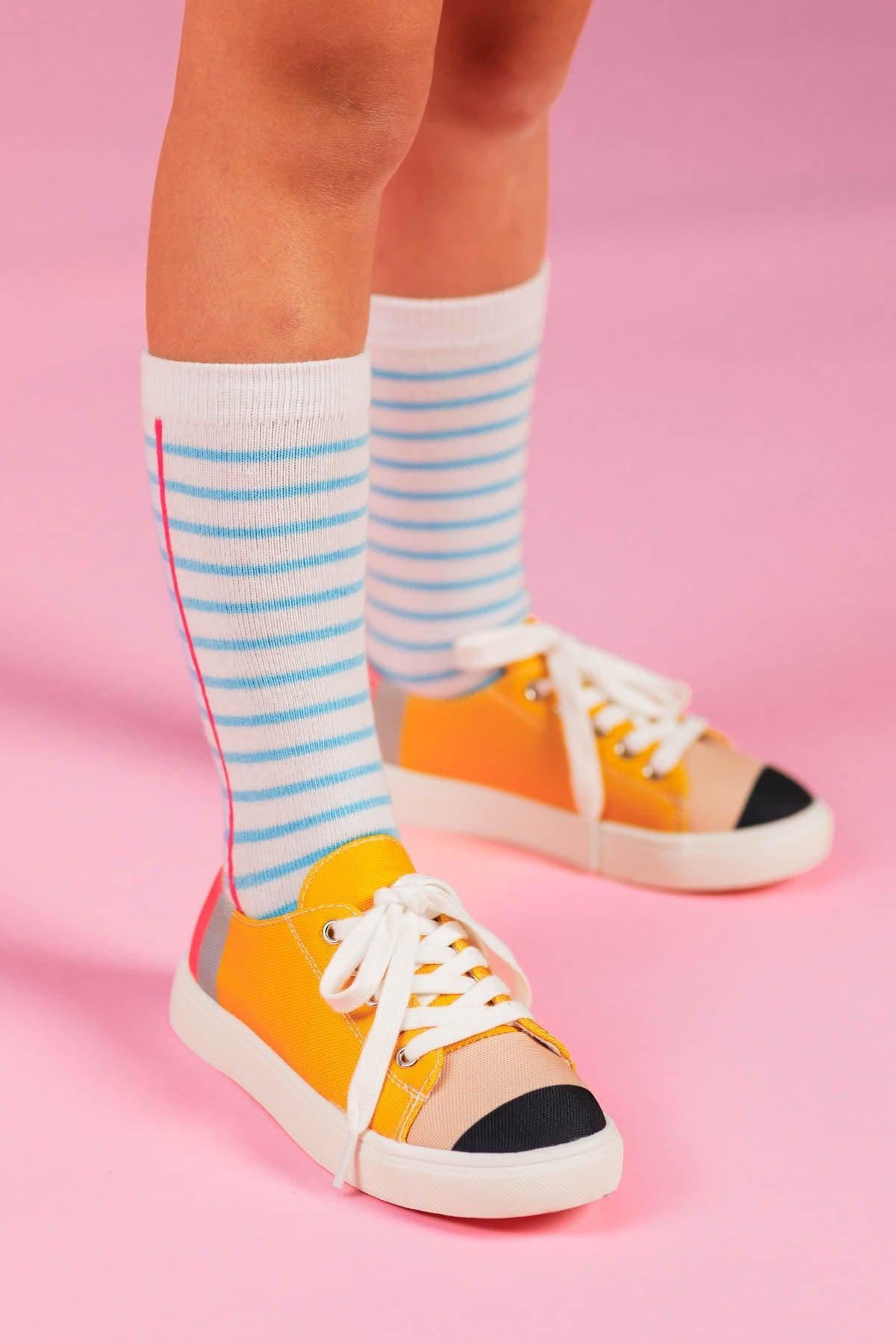 Pencil Sneakers - KIDS-8T - Kids' yellow sneakers with white laces and black toe caps paired with blue-striped socks.