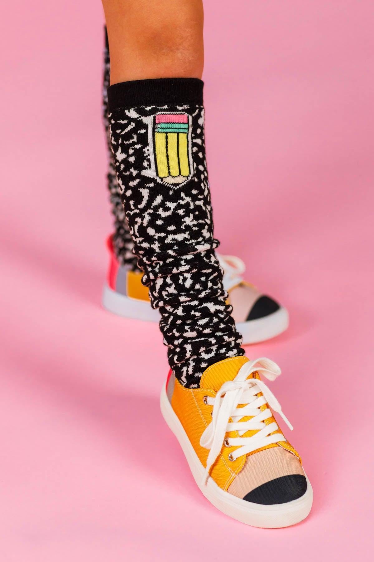 Composition Notebook Knee High Socks - Default Title - Black knee-high socks with white composition notebook print and a small colorful pencil patch near the top.