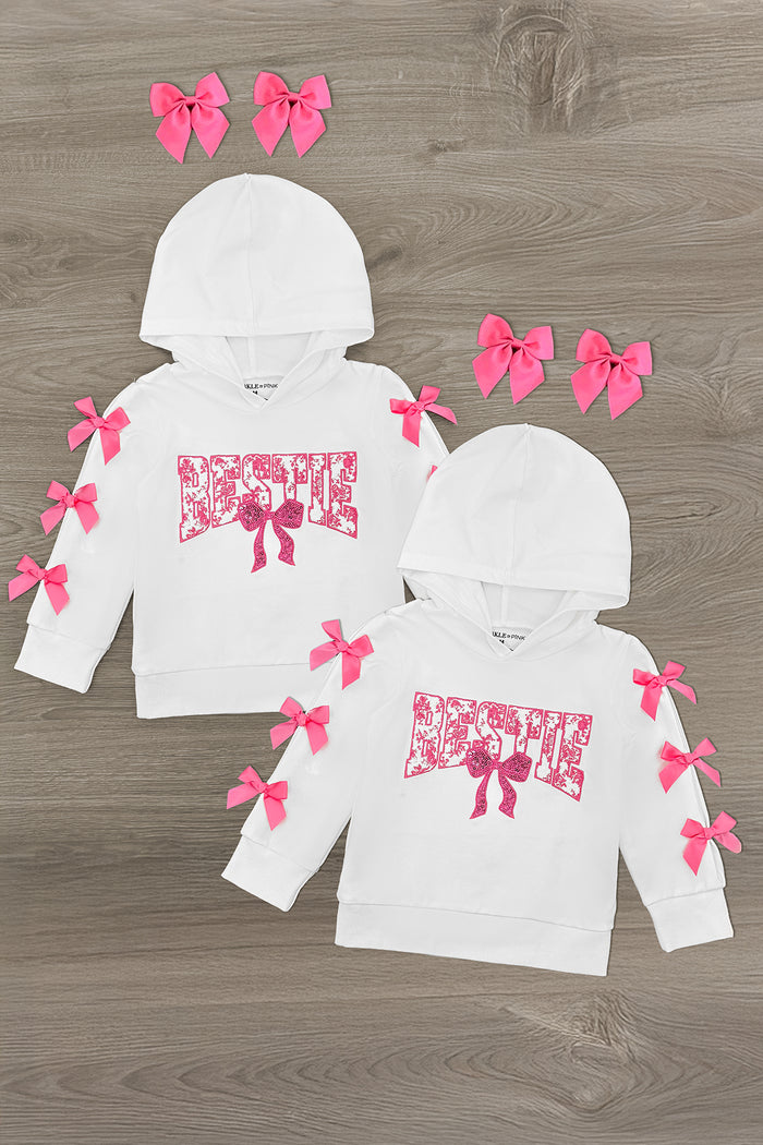 "Bestie" Pink Bow Hoodie - XXS-12-18 Months - White hoodie with pink bow accents on sleeves and hood, pink "Bestie" graphic on front, two sizes shown.
