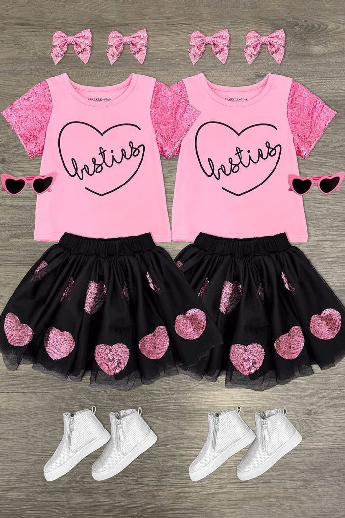 "Besties" Sequin Tutu Skirt Set - 3XS-6-12 Months - Pink short-sleeve tee with heart and "Besties" text, black tutu skirt with pink sequin hearts, white shoes, and pink bow.