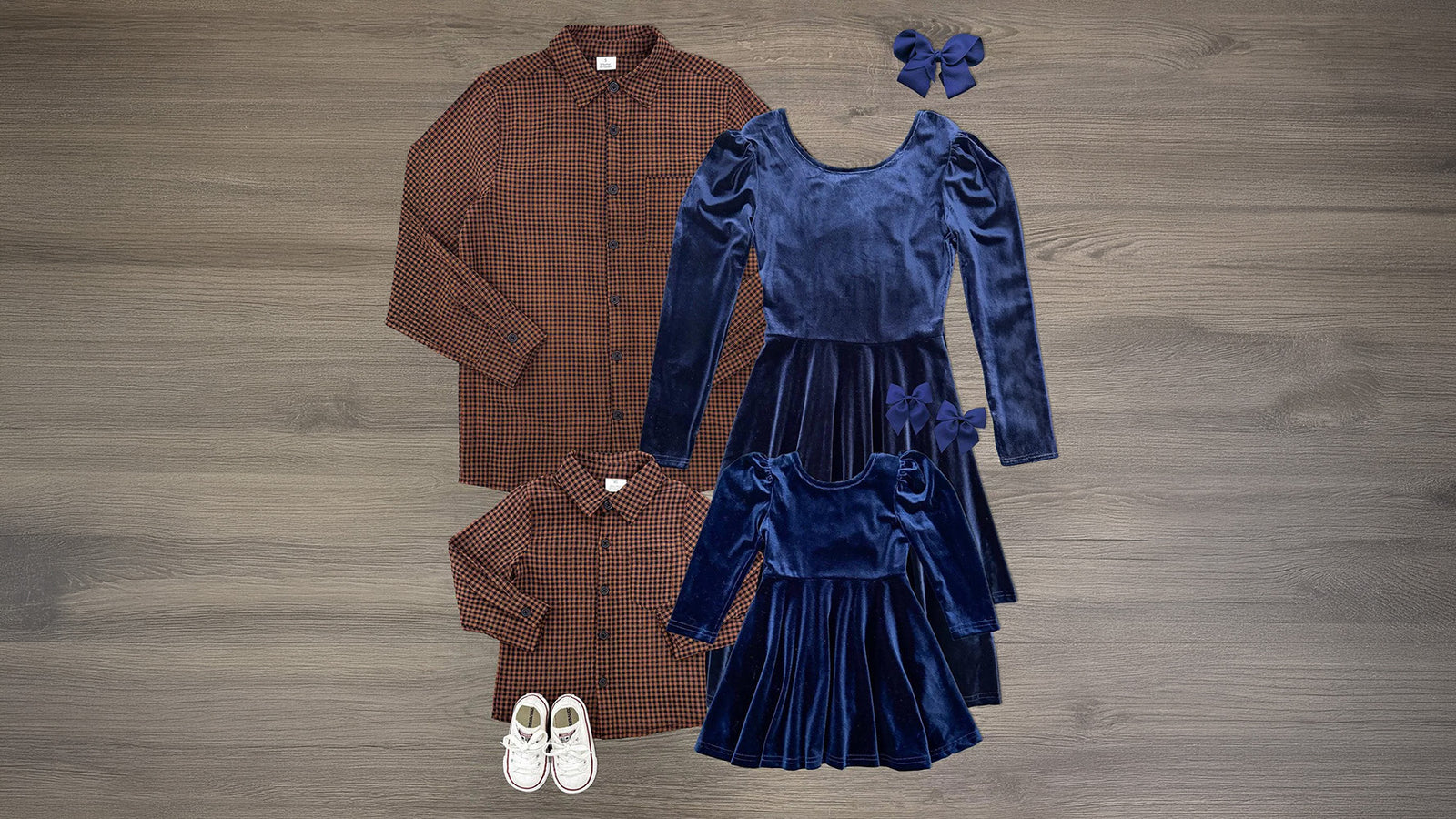 Family matching fall outfits with women and girls in navy velvet dresses and men and boys in brown gingham button-down shirts
