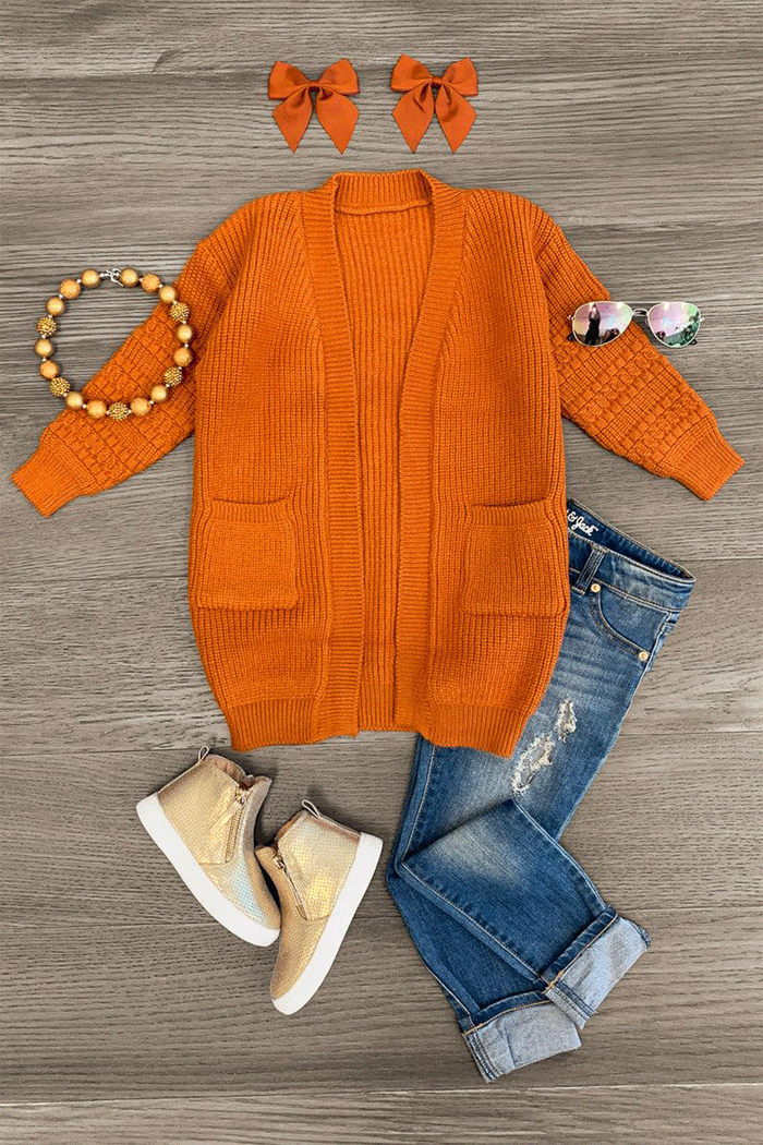 Cardigan Sweater - Rust / 3XS-6-12 Months - Rust-orange knit cardigan sweater with front pockets styled with denim jeans, beige sneakers, beaded bracelet, sunglasses,.