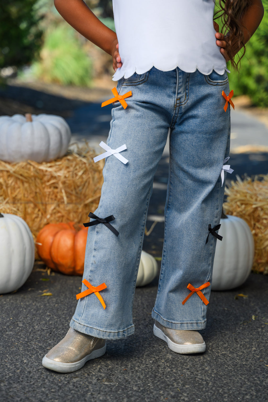 "Spooky Season" Bow Denim Pant Set - 6-12 Months - Light blue denim pants with wide legs featuring black, white, and orange bow accents on front thighs and lower legs.