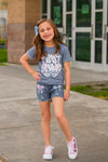 "Pre-K - Sixth Grade" Plaid Bow Denim Short Set - PRE-K / 2T - Girl wearing blue graphic t-shirt with pink and white text paired with denim shorts featuring pink plaid bow patches and.