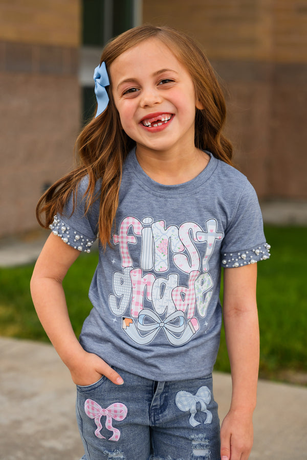 "Pre-K - Sixth Grade" Plaid Bow Denim Short Set - PRE-K / 2T - Blue short-sleeve shirt and matching denim shorts with pink and white plaid bow accents and "First Grade" text on shirt.