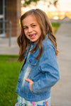 "Preschool - Sixth Grade" Denim Jacket - PRESCHOOL / 3T - Light blue denim jacket with front pockets and button closure, worn by young girl outdoors.