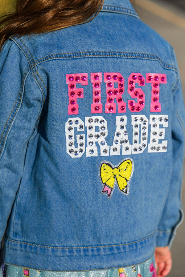 "Preschool - Sixth Grade" Denim Jacket - PRESCHOOL / 3T - Light blue denim jacket with pink and white studded "First Grade" text and a yellow bow patch on the back.