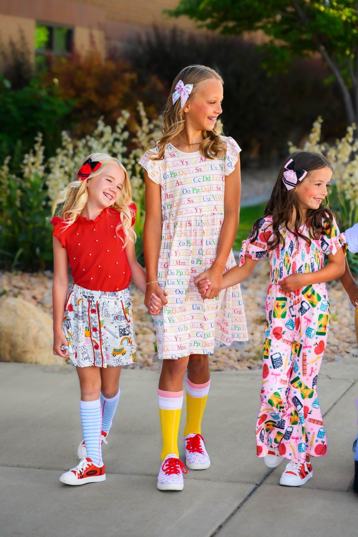 Mom & Me - White Alphabet Dress - CHILD-Small-3T - White cotton dress with colorful alphabet print, short sleeves, and a relaxed fit on a girl.