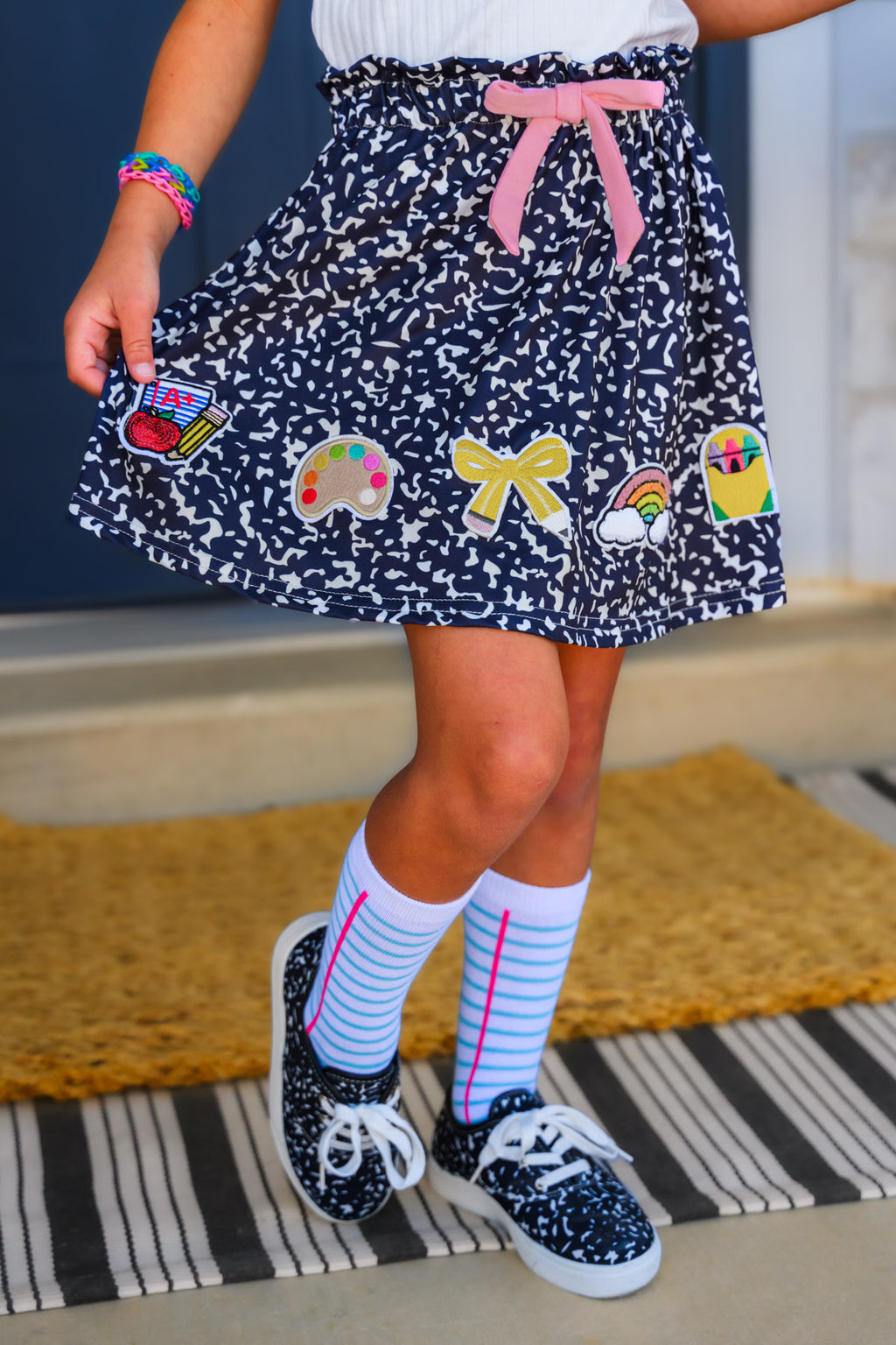 "Pre-K - Sixth Grade" Notebook Skirt Set - PRE-K / 2T - Navy blue notebook-print skirt with colorful school-themed patches and pink bow waistband.