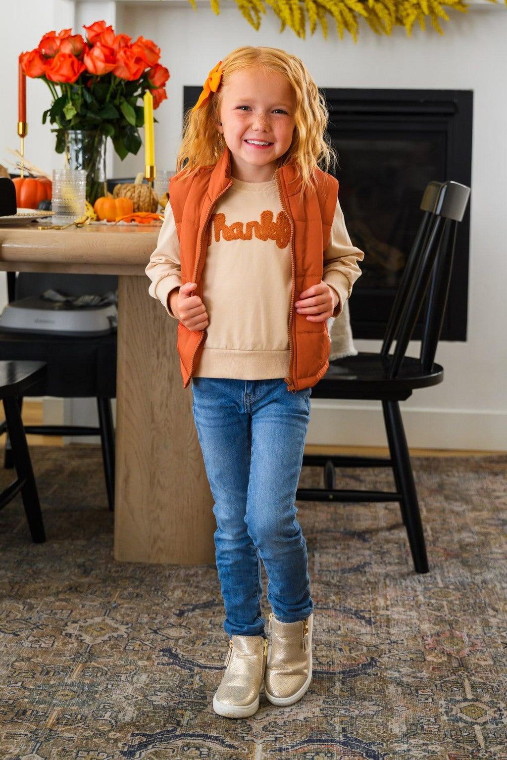 Mom & Me - "Thankful" Vest Set - CHILD-6-12 Months - Girl wearing a tan “Thankful” vest over an orange long-sleeve shirt with blue jeans and cream boots.