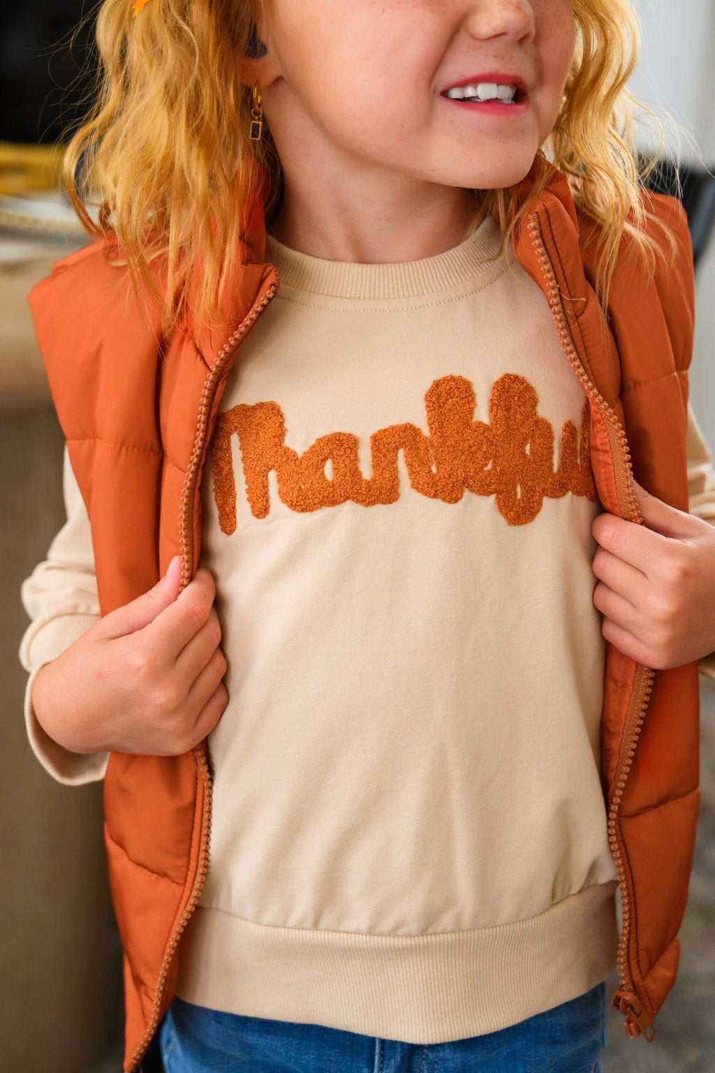 Mom & Me - "Thankful" Vest Set - CHILD-6-12 Months - Woman wearing a tan sweatshirt with orange “Thankful” lettering and an orange quilted vest.