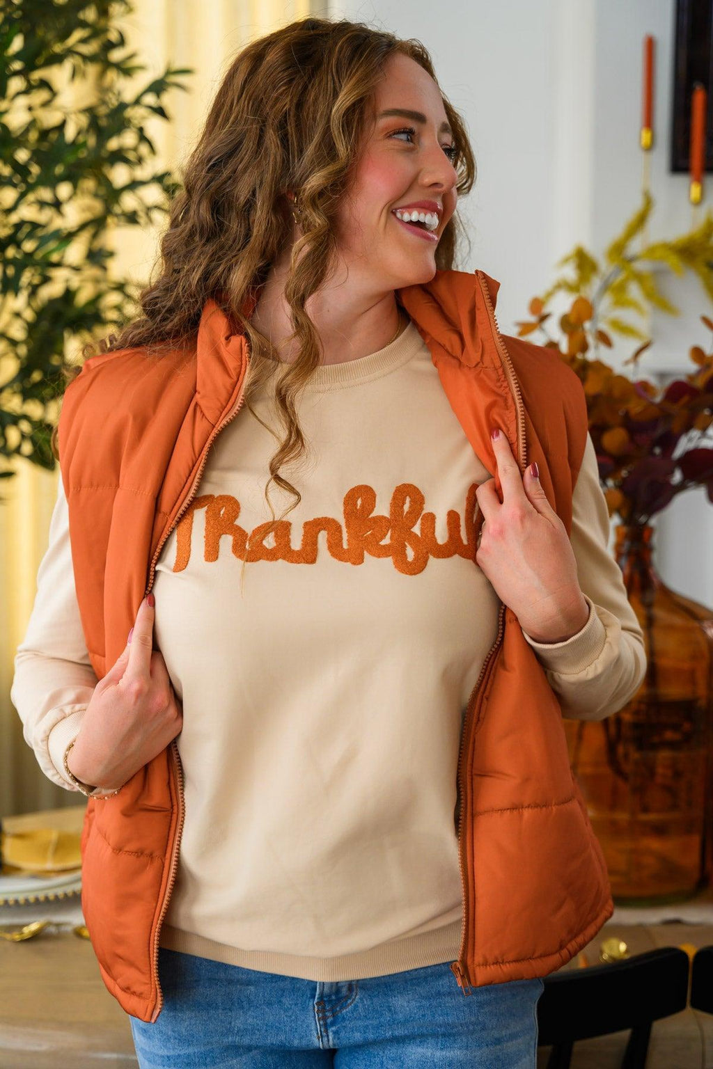 Mom & Me - "Thankful" Vest Set - CHILD-6-12 Months - Woman wearing a cream “Thankful” sweatshirt with orange lettering and a rust-orange quilted vest.