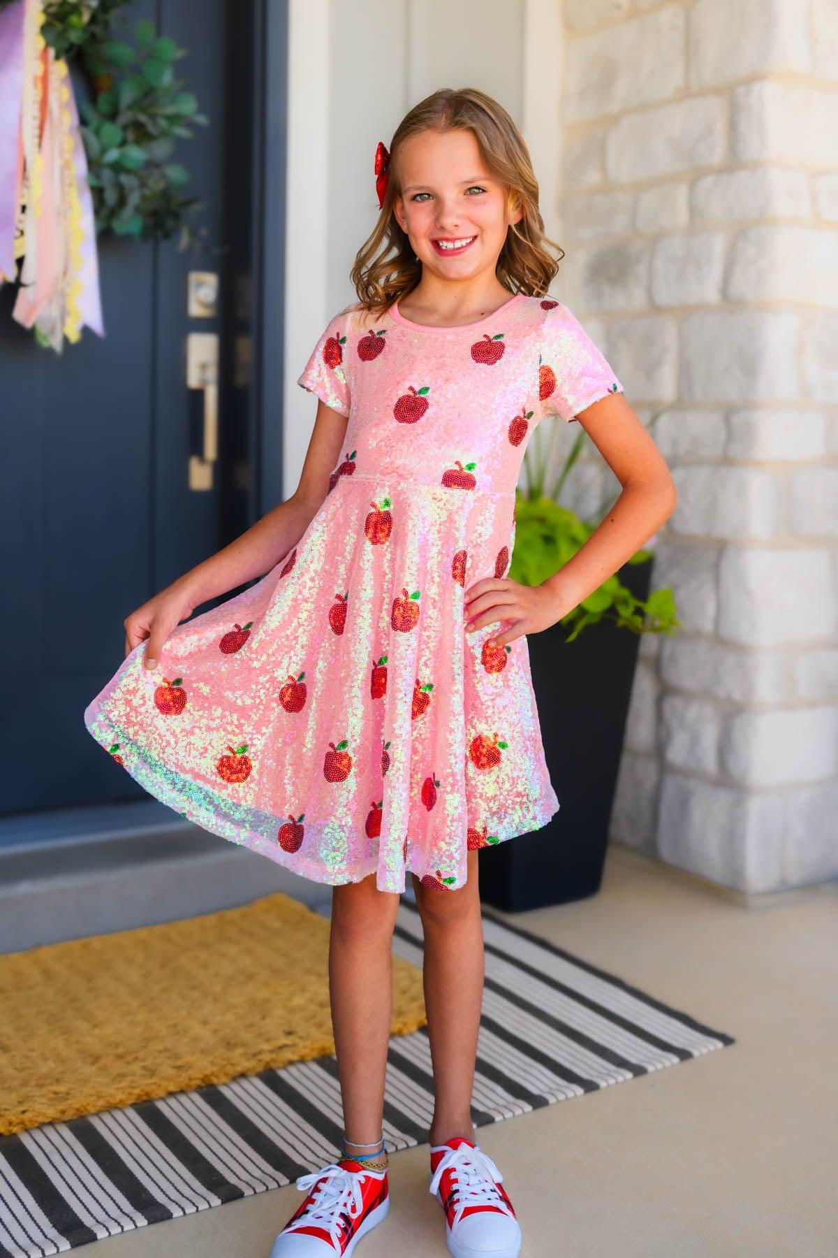 Mom & Me - Pink Sequin Apple Dress - CHILD-2T - Pink sequin dress with apple patterns, short sleeves, and full skirt worn by a smiling child.