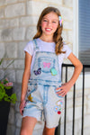 Summer Patches Denim Overalls - 6-12 Months - Light blue denim overalls with colorful summer-themed patches and distressed hems, worn over a white short-sleeve t-shirt.