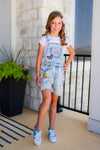 Summer Patches Denim Overalls - 6-12 Months - Light-wash denim overall shorts with colorful summer-themed patches worn over a white t-shirt, paired with white sneakers.