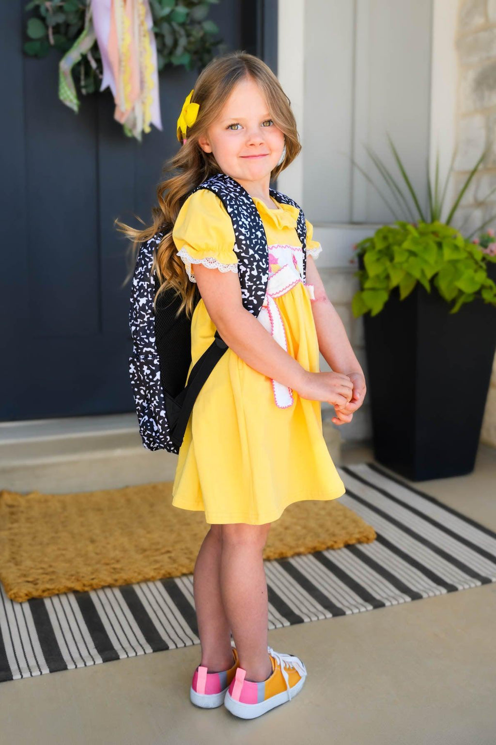 Composition Notebook Chenille Patch Backpack - Default Title - Black and white chenille patch backpack with embroidery worn by girl in yellow dress and pink sneakers.
