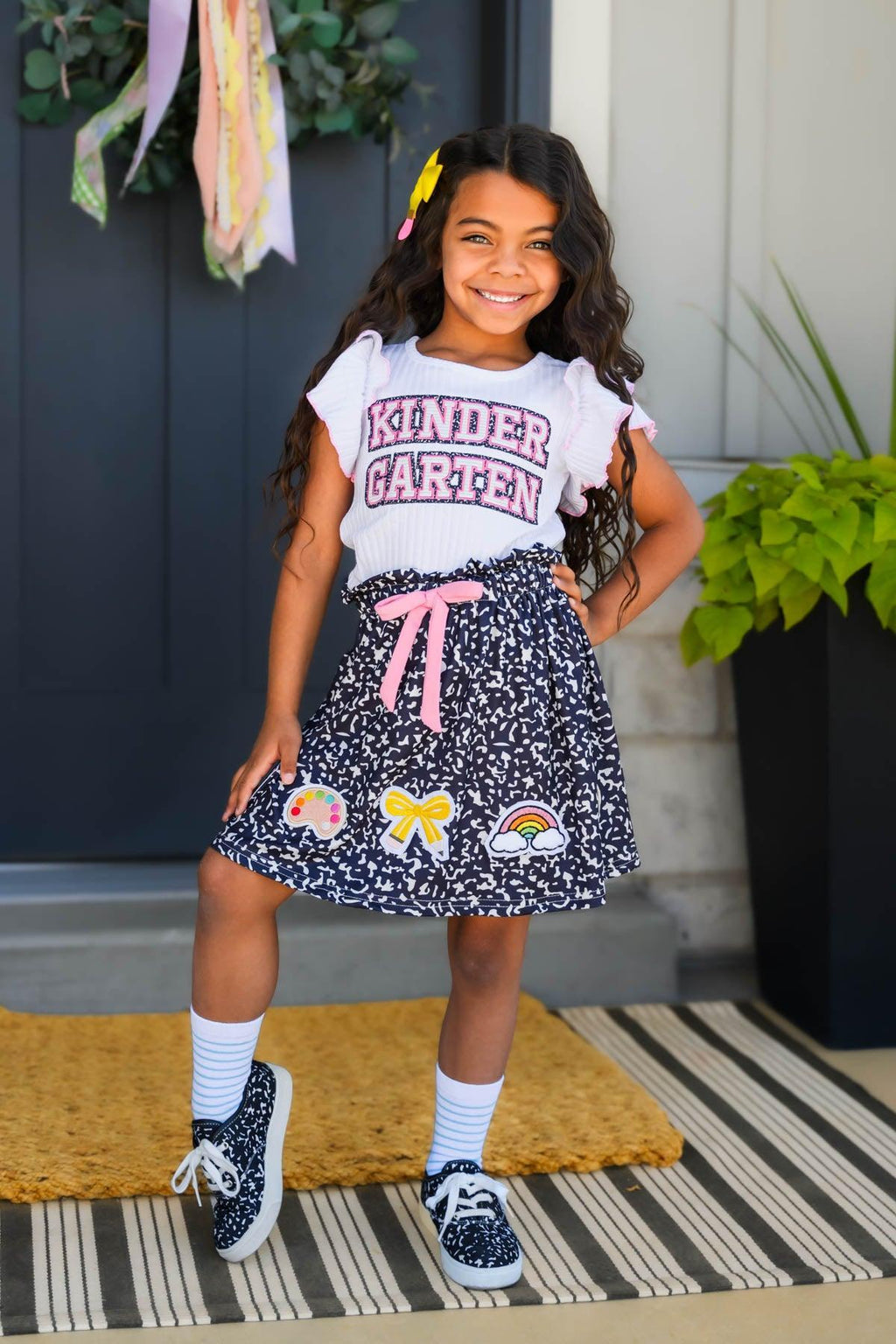 "Pre-K - Sixth Grade" Notebook Skirt Set - PRE-K / 2T - Black skirt with white notebook paper print, colorful bows and rainbows, paired with a white "Kindergarten" graphic tee and.