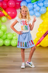 "Be Kind" Crayon Skirt Set - 3T - White short-sleeve t-shirt with colorful "Be Kind" text paired with a light blue skirt featuring rainbow crayon appliques.