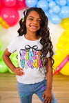 "Pre-K - Sixth Grade" Bow Denim Pant Set - PRE-K / 2T - Girl wearing white ribbed short-sleeve top with colorful "First Grade" text and black bow graphic, paired with light blue.