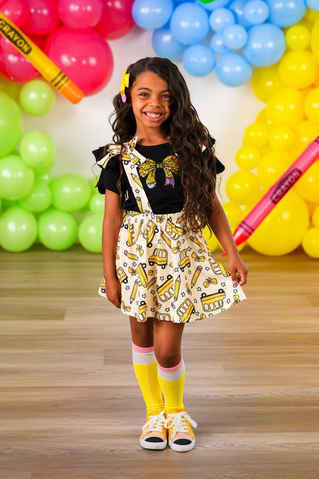 Pencil Bow Suspender Skirt Set - 3T - Yellow pencil pattern suspender skirt with black bow details, paired with black t-shirt and yellow socks.