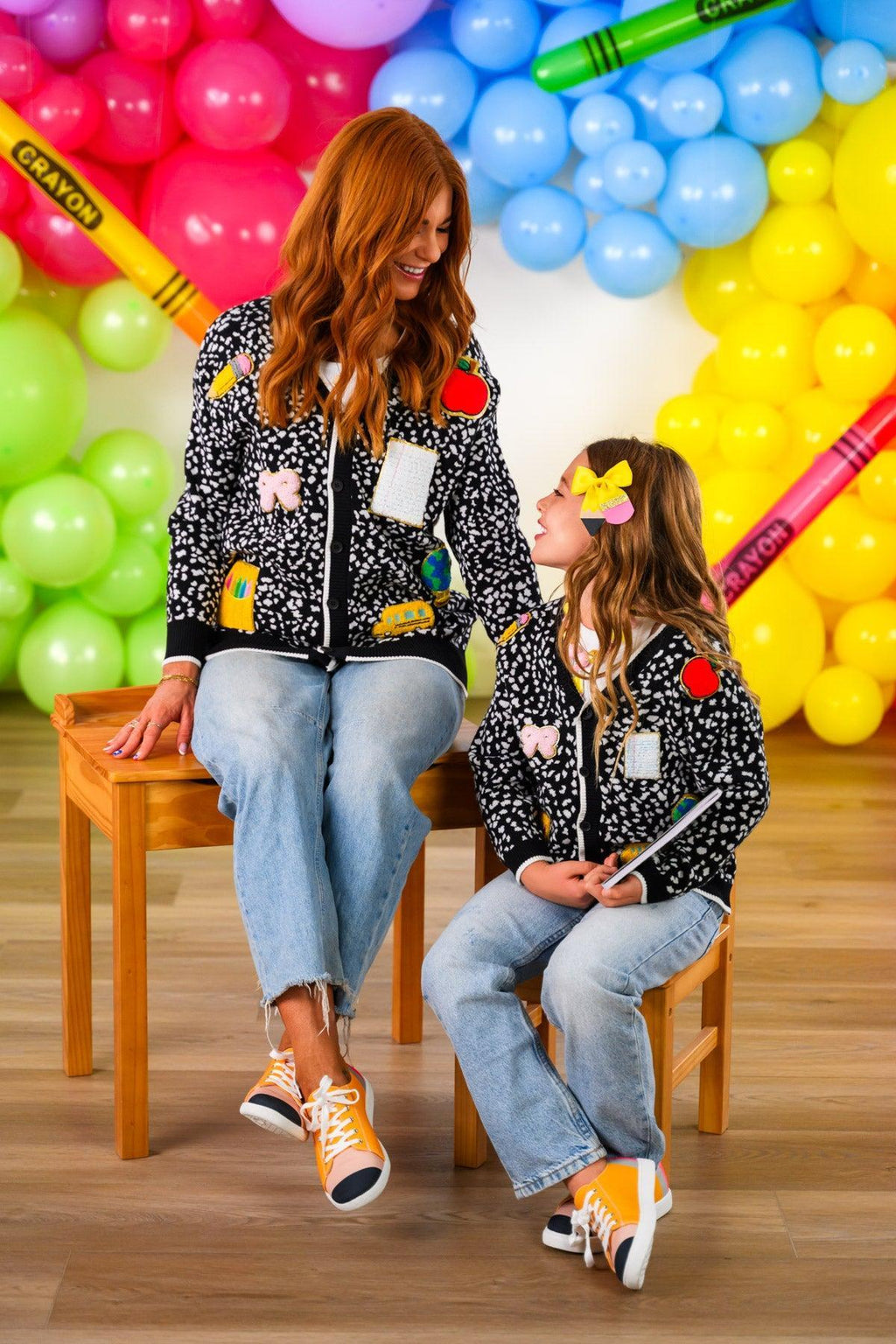 Mom & Me - Composition Sweater Cardigan - CHILD-3T - Black knit sweater cardigans with multicolored patch designs worn by woman and girl, paired with light blue jeans and.