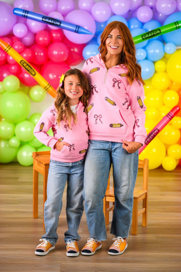 Mom & Me - Pink Pencils & Bows Pullover - 3T - Matching pink pullover sweaters with pencil and bow prints, worn by mother and daughter, paired with jeans and sneakers.
