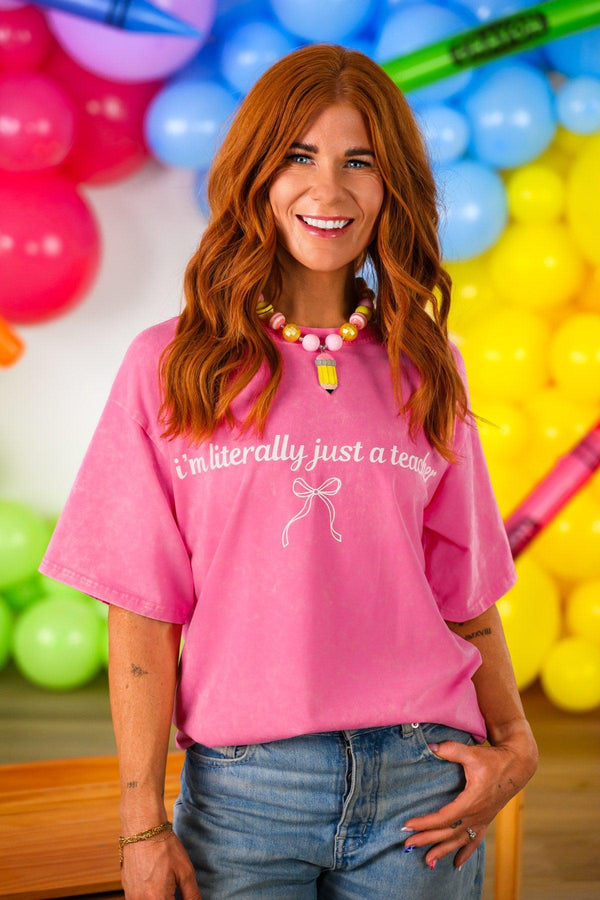 "I'm Literally Just A Teacher" Pink Top - MOM-XS - Pink short-sleeve casual top with white "I'm literally just a teacher" text and small bow graphic on front.