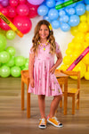 Mom & Me - Pink Pencil & Bow Dress - CHILD-3T - Pink sleeveless dress with pencil and bow print, flared skirt, worn with orange sneakers.