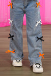"Spooky Season" Bow Denim Pant Set - 6-12 Months - Light blue denim pants with colorful bow accents in orange, white, and black down the legs.
