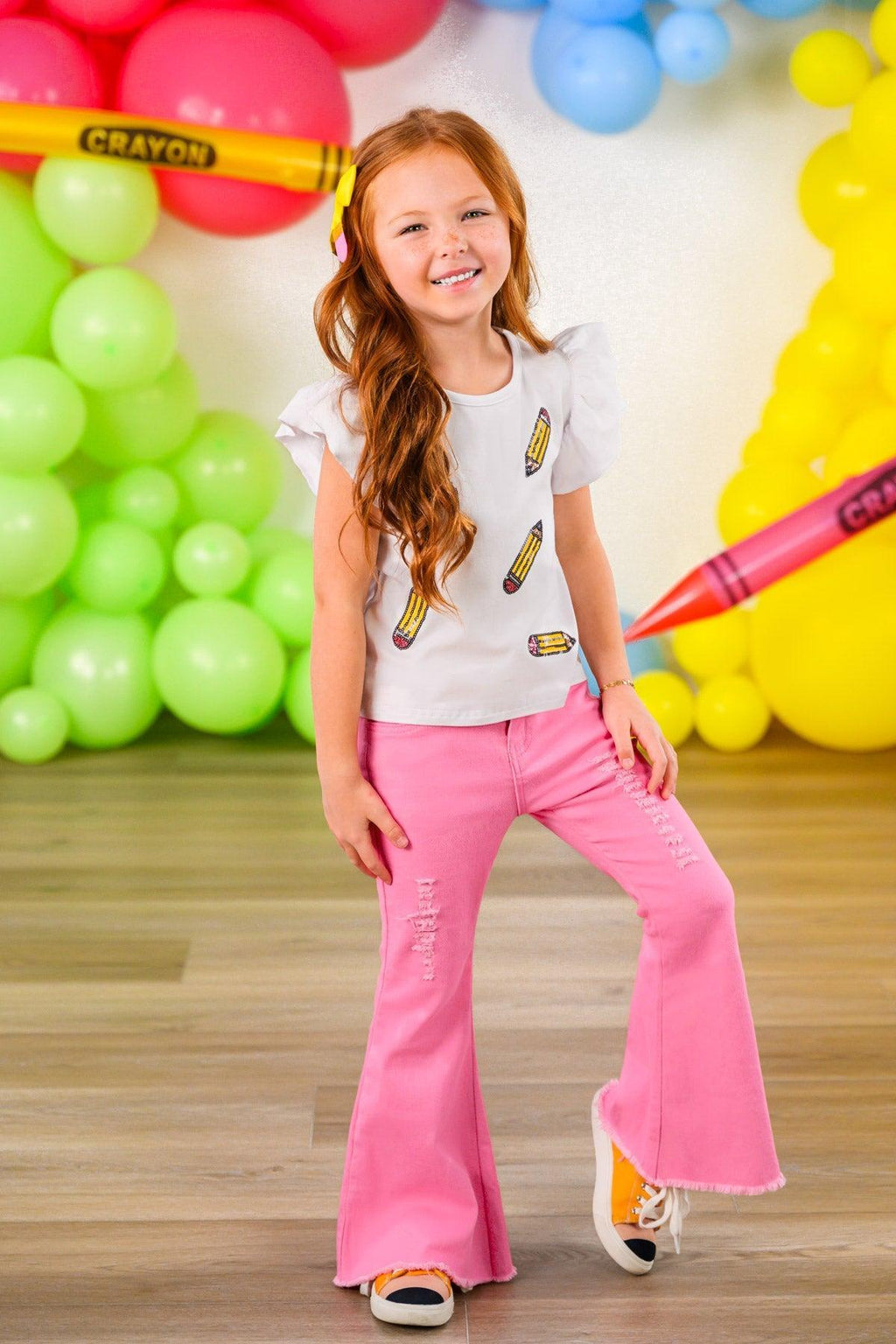 Pink Pencil Flare Denim Pant Set - 3T - Girl wearing pink flare denim pants and a white short-sleeve top with colorful popsicle prints.