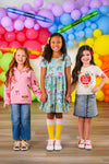 Mom & Me - Pink Pencils & Bows Pullover - 3T - Pink pullover with pencil and bow prints, paired with blue jeans on a young girl against colorful balloon backdrop.