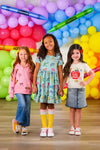 "Pre-K - Fifth Grade" Apple Denim Skirt Set - PRE-K / 2T - Girls wearing a light blue denim skirt with front buttons and a white long-sleeve top with a red apple graphic.