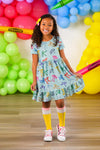 Mint Glitter School Bows Dress - 3T - Mint green short-sleeve dress with colorful glitter school bow patterns and a flared skirt worn by a smiling girl.