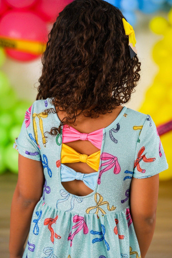Mint Glitter School Bows Dress - 3T - Light blue dress with colorful bow prints, short sleeves, and three twisted back cutouts with pink, yellow, and blue fabric.
