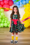 Green Glitter School Supplies Dress - 3T - Green dress with school supply print, glitter accents, red bow waist, and short sleeves on girl.
