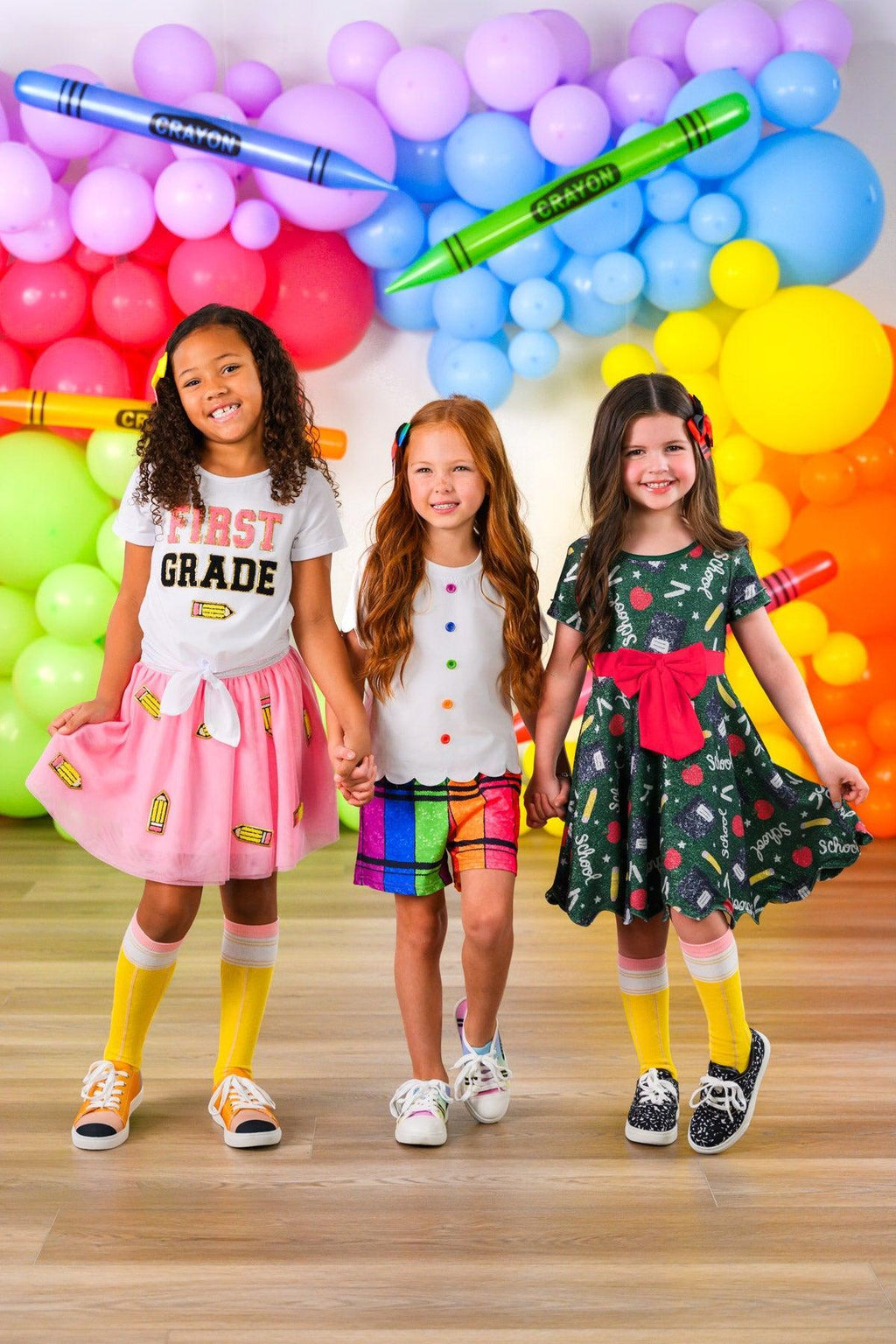 Crayon Short Set - 3T - Pink tutu with "First Grade" top, rainbow plaid shorts with white shirt, and black dress with crayon patterns and red bow.