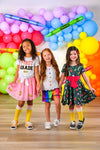 "Pre-K - 6th Grade" Pink Pencil Tutu Skirt Set - PRE-K / 2T - Three girls wearing colorful back-to-school outfits with a pink pencil tutu skirt, plaid shorts, and a floral dress standing