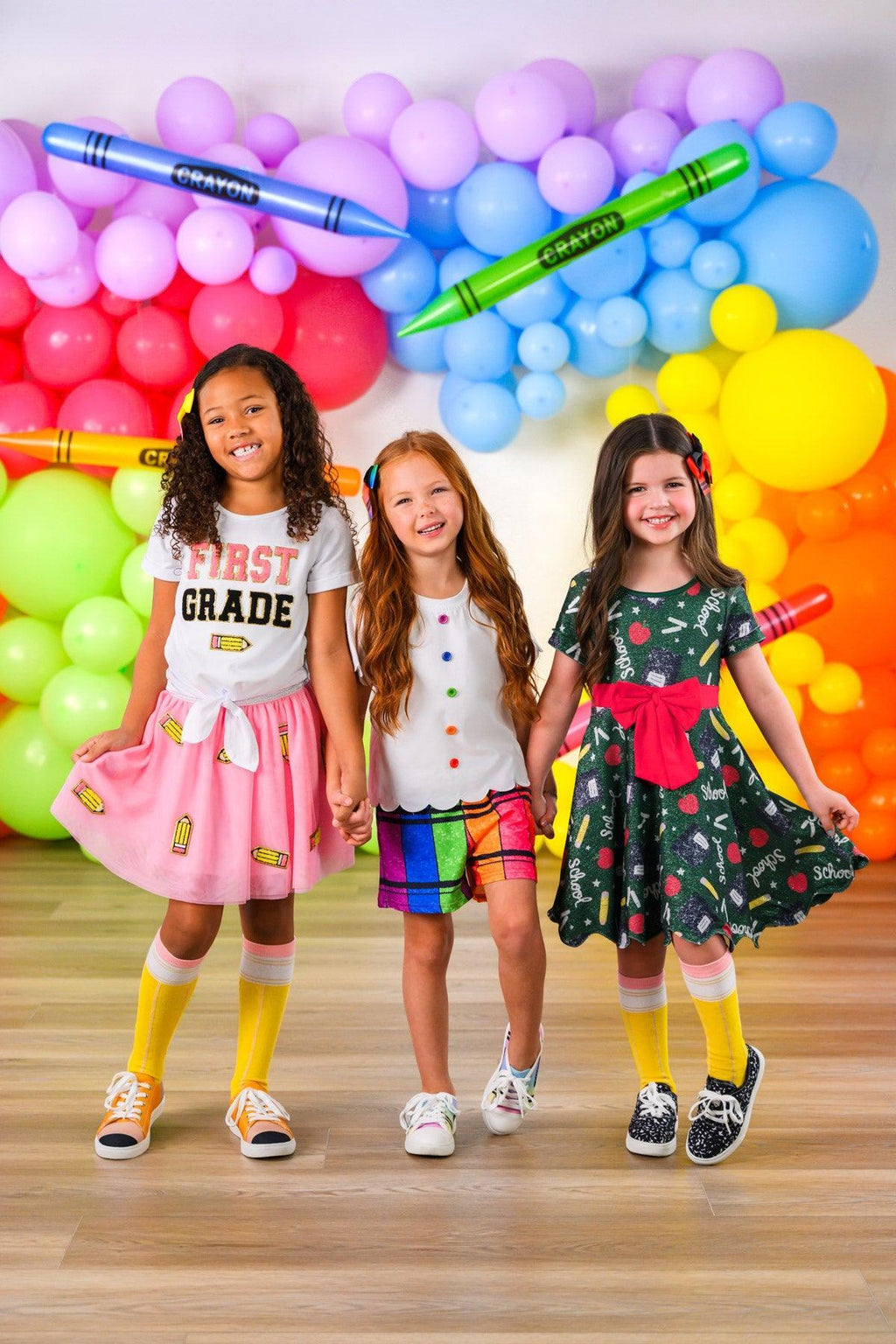 "Pre-K - 6th Grade" Pink Pencil Tutu Skirt Set - PRE-K / 2T - Three girls wearing colorful back-to-school outfits with a pink pencil tutu skirt, plaid shorts, and a floral dress standing