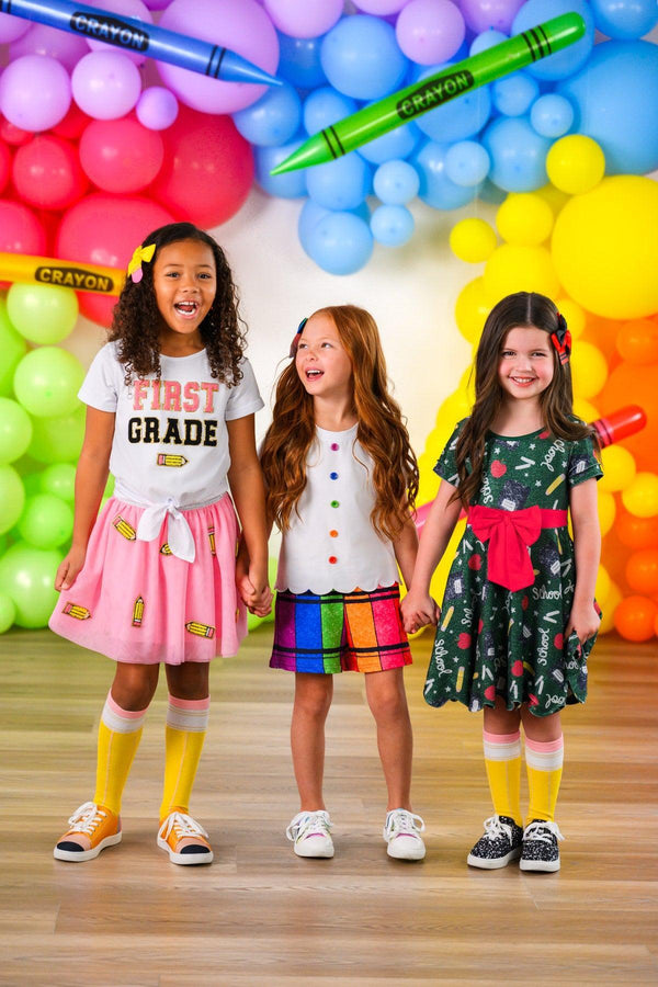 Crayon Short Set - 3T - Pink skirt with graphic tee, rainbow plaid dress, and black floral dress, each paired with knee-high yellow socks.