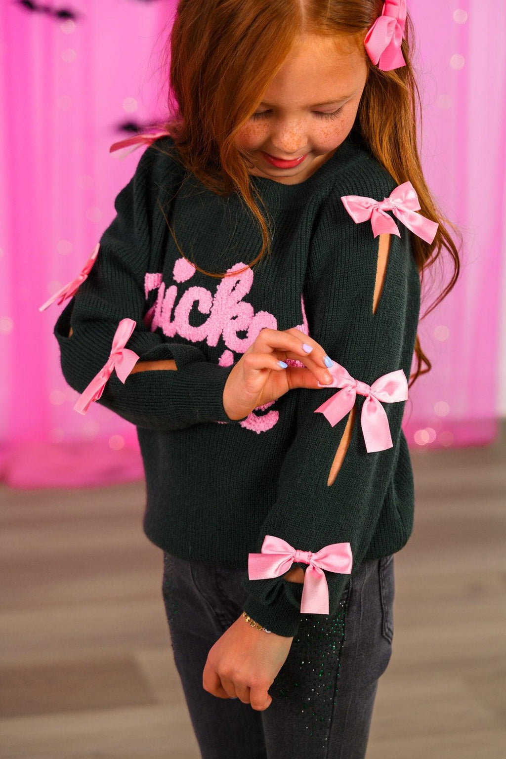 "Wicked Cute" Denim Flare Set - 6-12 Months - Black long-sleeve shirt with pink "Wicked" script and pink bows along the sleeves worn by a young girl.