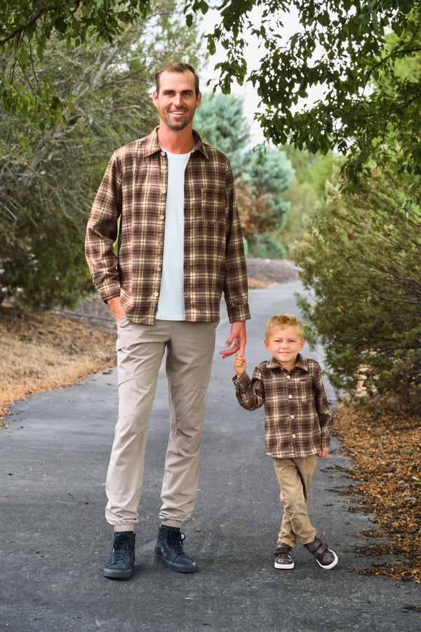 Family Brown Dress & Flannel - GIRL-6-12 Months-FAMILY - Men's and toddler's brown plaid flannel shirts paired with beige pants on a paved outdoor path.
