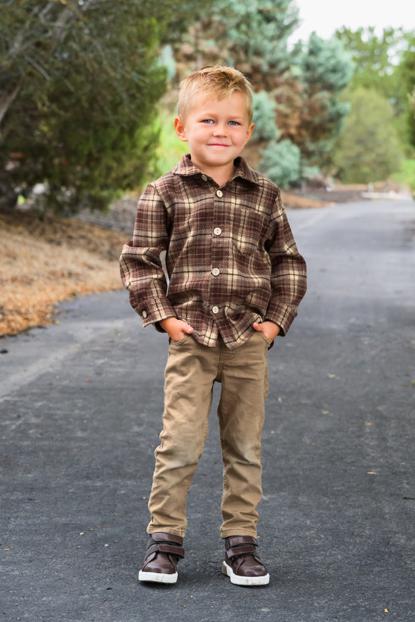 Family Brown Dress & Flannel - GIRL-6-12 Months-FAMILY - Brown plaid flannel shirt with button front and chest pockets, paired with tan pants and dark sneakers on a child outdoors.