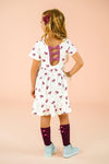 Pink Flowers & Bows Dress - 6-12 Months - White dress with pink floral print, short sleeves, and back bow detail, worn by child.