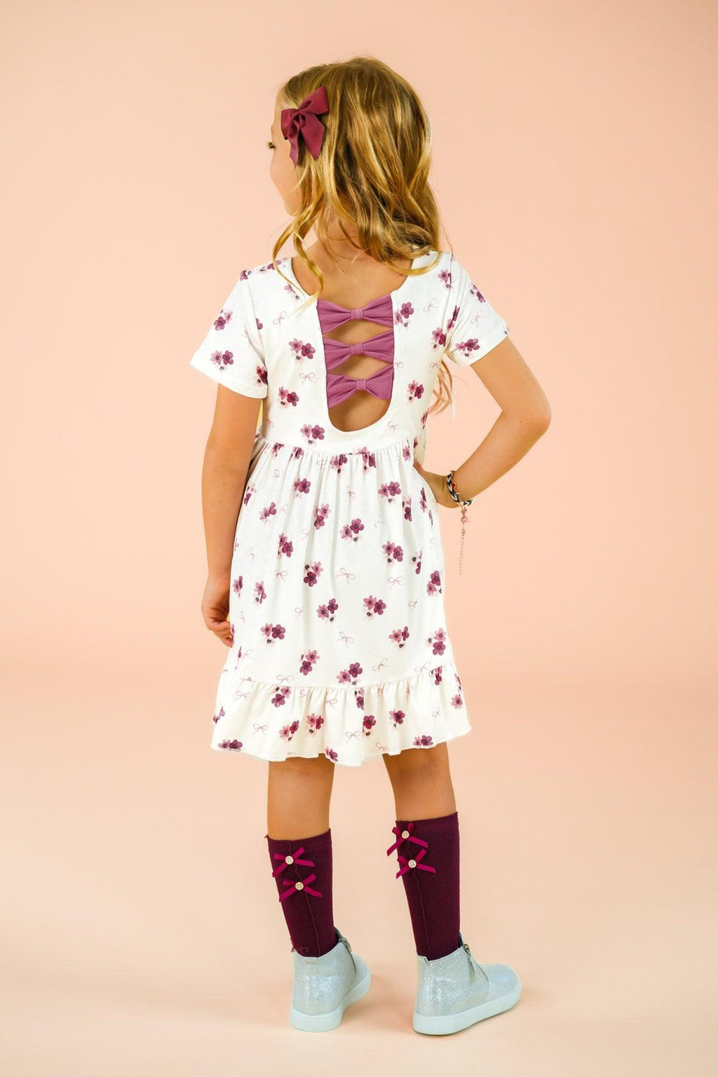 Pink Flowers & Bows Dress - 6-12 Months - White dress with pink floral print, short sleeves, and back bow detail, worn by child.