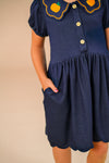 Faux Denim Pumpkin Dress - 6-12 Months - Navy blue faux denim pumpkin dress with scalloped hem, puff sleeves, front buttons, and decorative collar with orange.