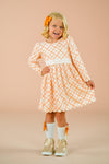 Orange Plaid Bow Dress - 6-12 Months - Orange and white plaid long-sleeve dress with a large bow detail and gathered waist, worn by a smiling child with matching.