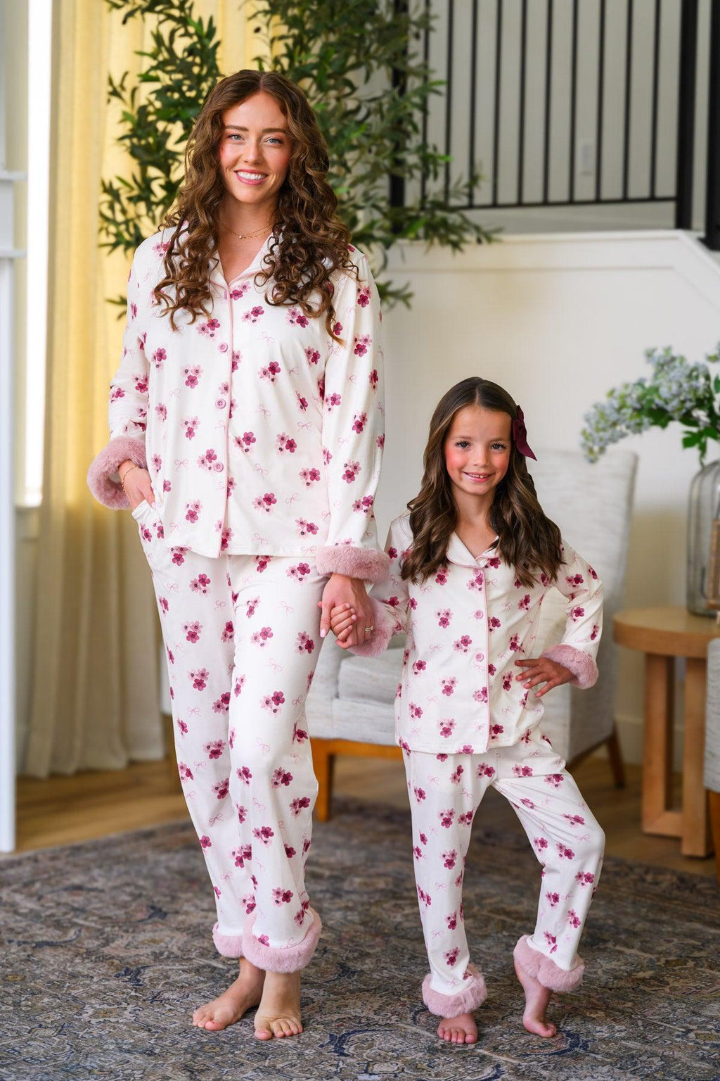 Mom & Me - Fuzzy Flower & Bow Pajamas - CHILD-6-12 Months - Cream-colored fuzzy pajamas with pink floral print and bow accents, long sleeves, and cuffed pants, worn by mother and.